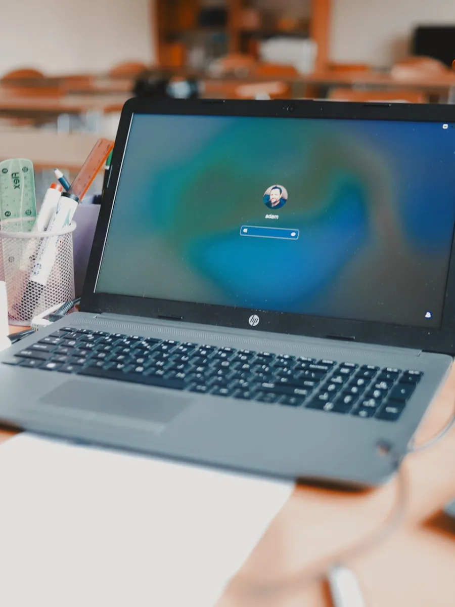 Notebook aberto sobre uma mesa em sala de aula