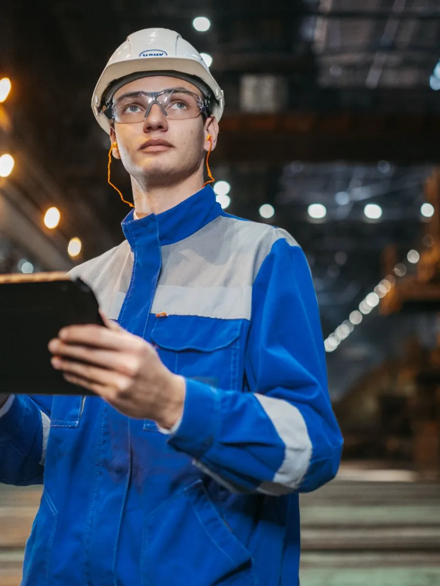 Profissional de indústria conferindo a produção com um tablet na mão