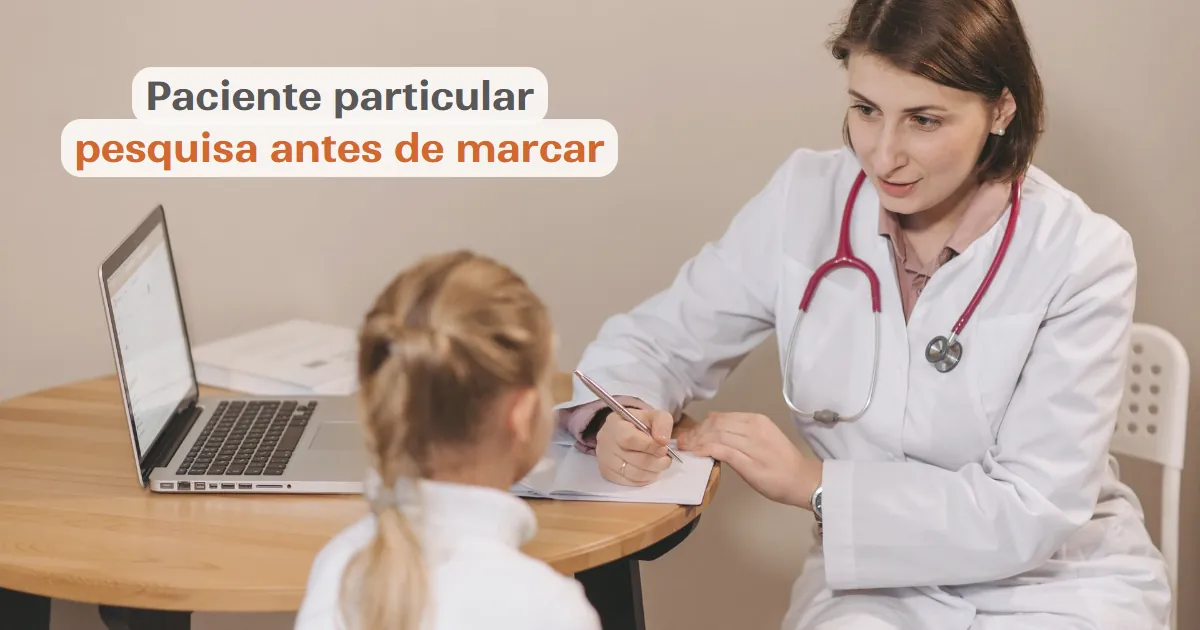 Médica em consultório atendendo uma paciente, com notebook aberto sobre a mesa