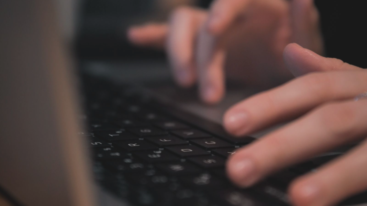 Mãos digitando em notebook: revisando por que um site bonito não traz cliente