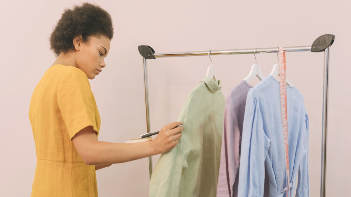 Dona de loja de roupas organizando arara, exemplo de quem sente que sua estratégia de marketing não dá resultado